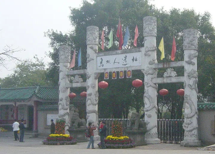 Ornate stone archway gate inscribed with Maba Man Site, flanked by stone lions