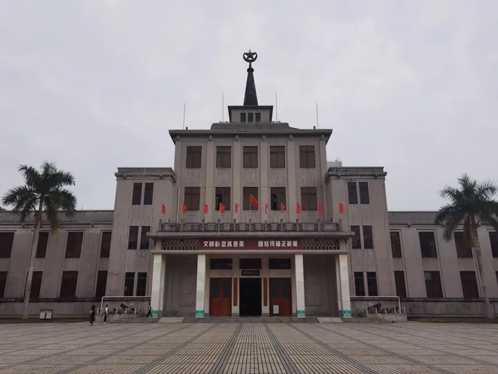 Exterior of the Zhanjiang Museum building with flags and palm trees
