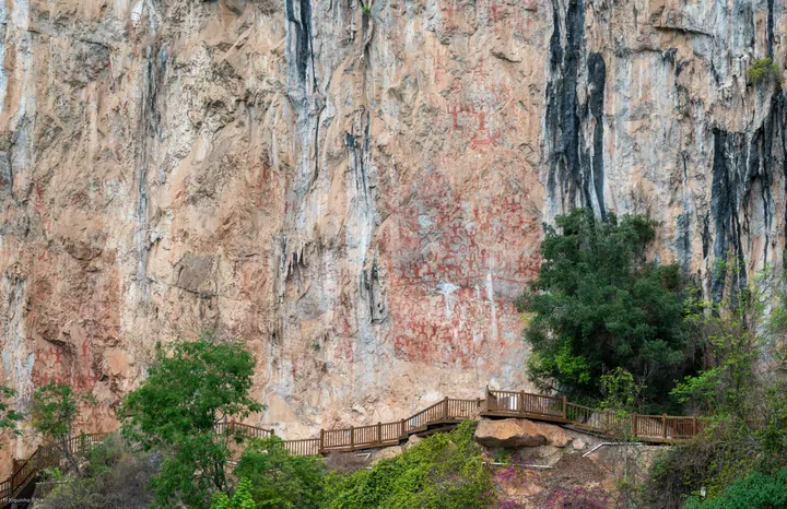 Cliff-face rock paintings and boardwalk at Huashan Rock Art, Ningming County