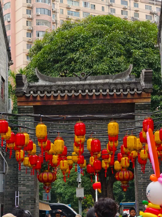 Traditional brick gate decorated with red and gold lanterns, Nanning