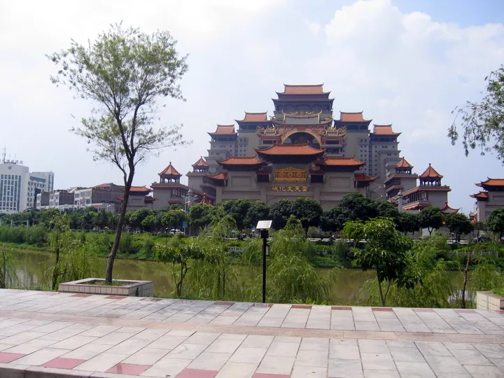 Ornate multi-tiered Yuntian Cultural City building beside a river