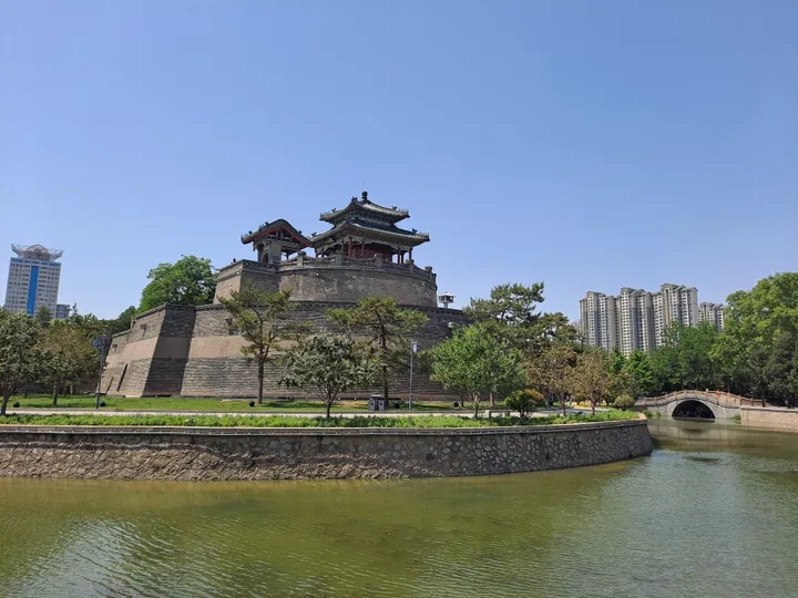 Ancient earthen terrace topped by a pavilion, surrounded by a moat, in Congtai Park