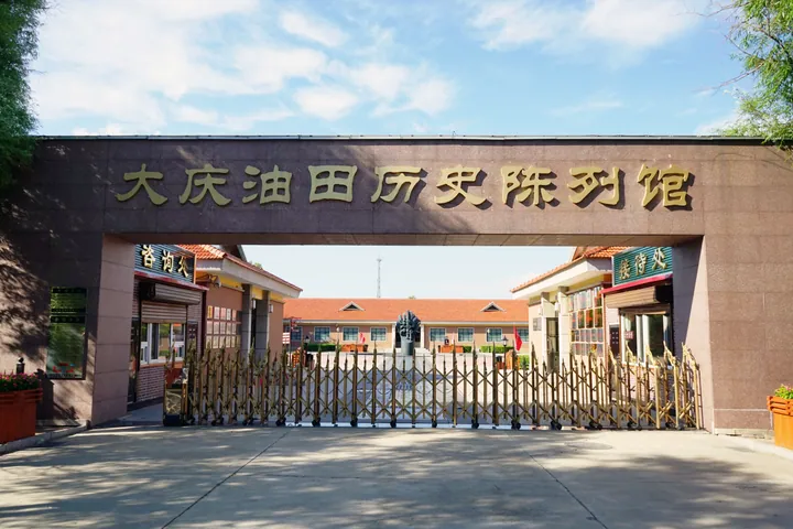 Museum entrance archway with large gold lettering and a courtyard beyond