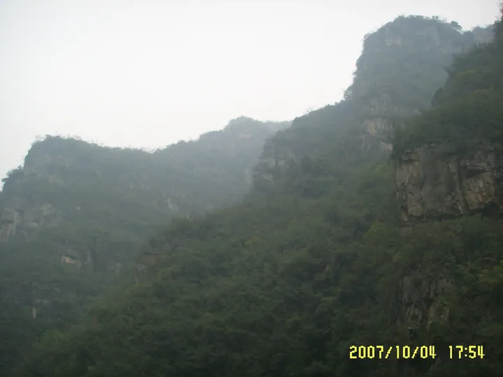 Forested limestone cliffs shrouded in mist at Qingtian River