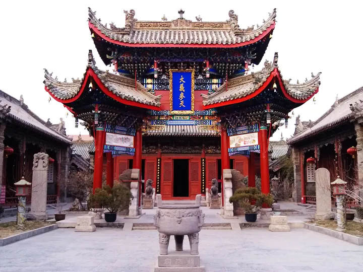 Elaborately carved red and gold archway within the Shan-Shaan-Gan Guild Hall courtyard