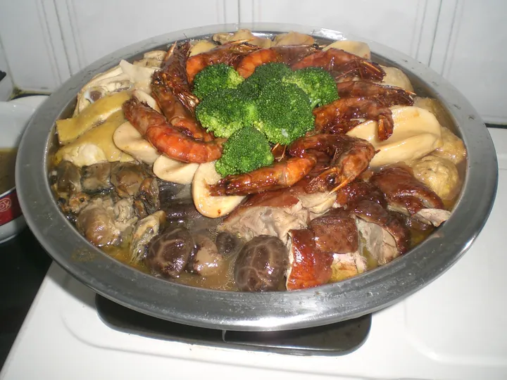 Large metal tray of layered shrimp, mushrooms, meat and broccoli