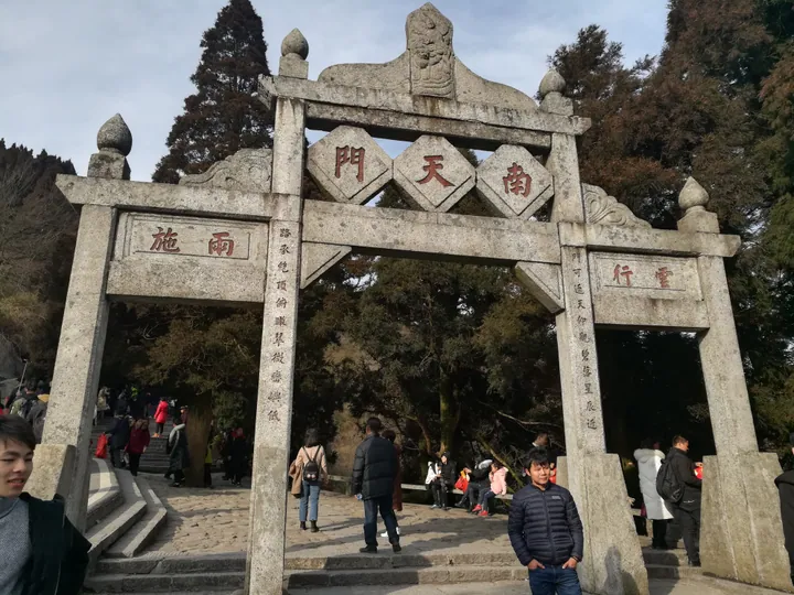 Stone archway gate on Mount Heng with visitors passing through