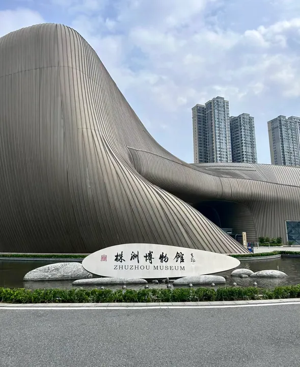 Zhuzhou Museum entrance with wave-like metal facade and museum sign