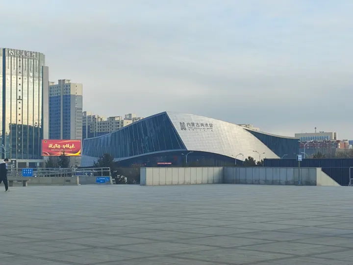 The sail-like metal-clad exterior of the Inner Mongolia Art Museum with its Chinese name on the façade