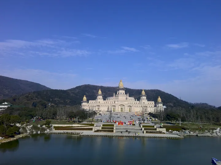 Grand domed Brahma Palace building reflected in a lake at Lingshan Scenic Area