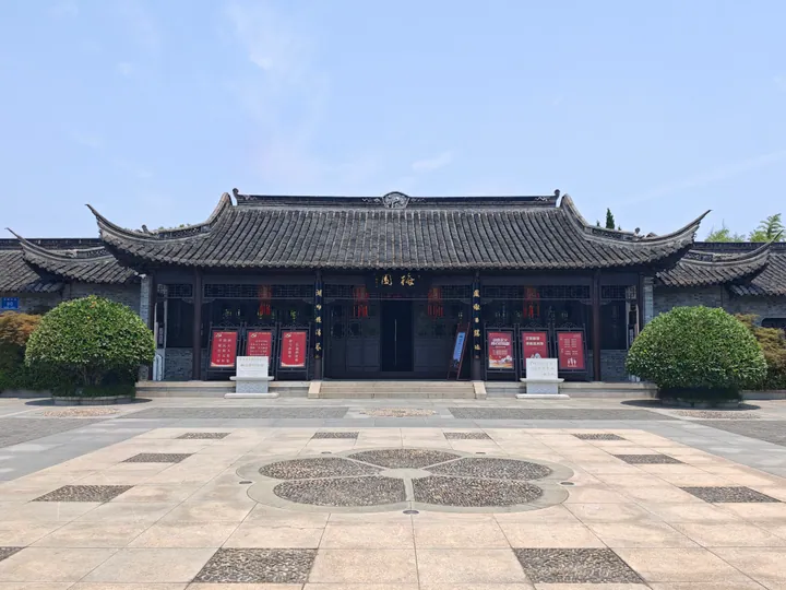 Traditional Chinese gate building with red doors and banners, the entrance of a memorial museum