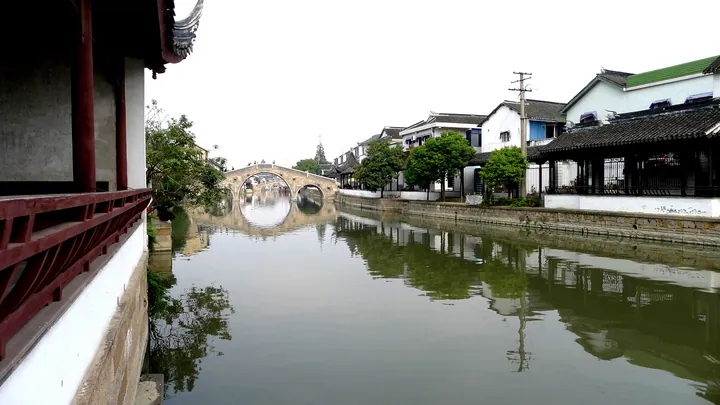 Canal-side street in Qiandeng old town with an arched stone bridge