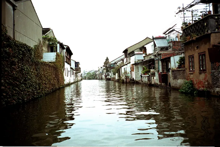 Canal lined with old white-walled houses reflected in the water