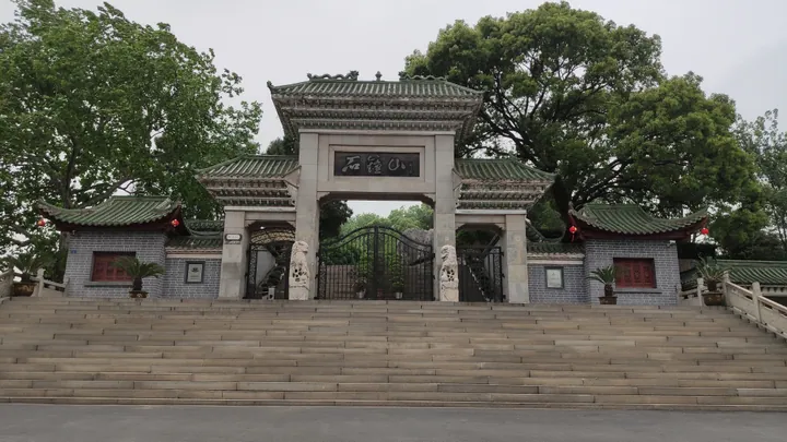 Stone archway gate to Stone Bell Hill scenic area with its name inscribed