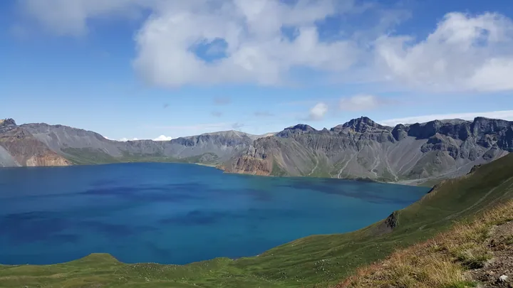 The deep blue crater lake of Tianchi framed by the rocky peaks of Changbai Mountain's west slope