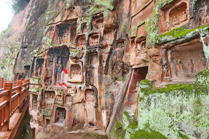 Rows of carved Buddha niches in the cliff at Qianfoyan grottoes