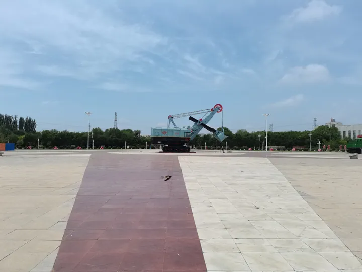 Large blue mining excavator displayed on the plaza of Haizhou Open-pit Mine National Mining Park