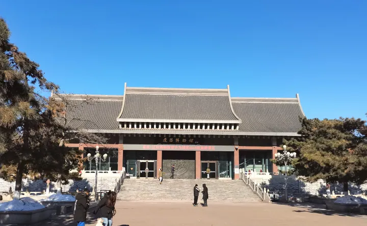 Traditional-roofed museum building under a clear blue sky