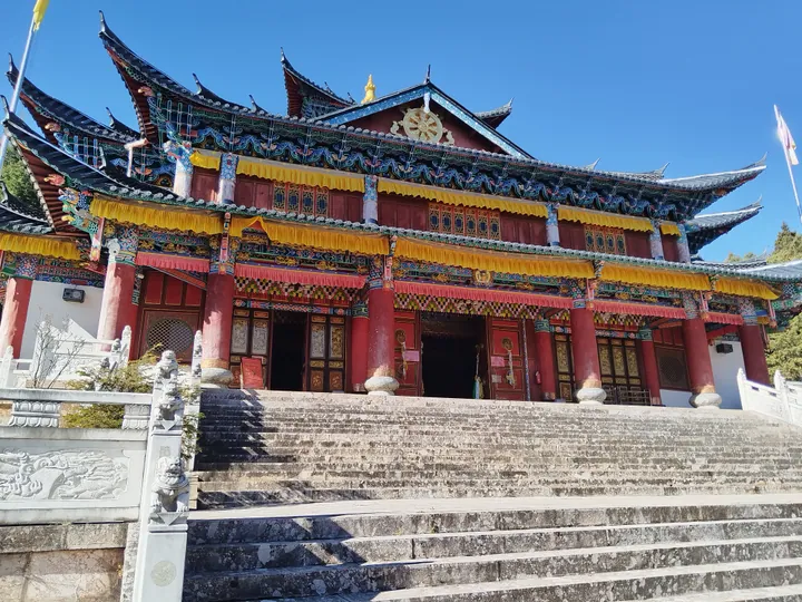 Colorfully painted temple hall with upturned eaves and a stone staircase