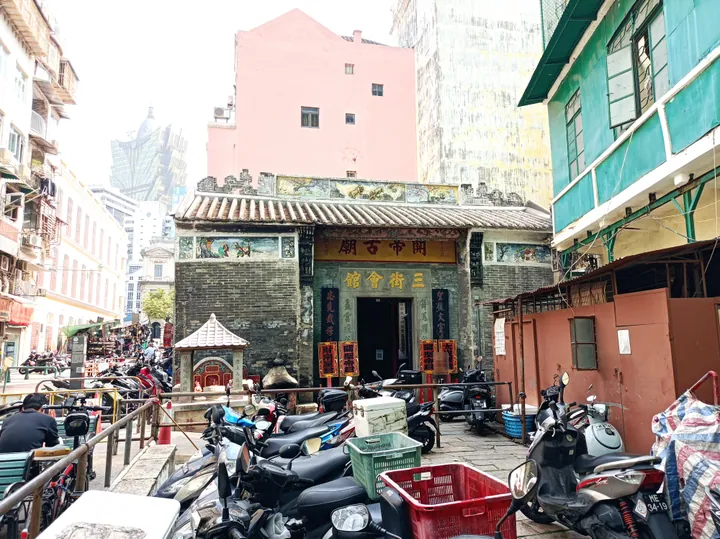 Weathered brick temple facade with a carved frieze and the name Sam Kai Vui Kun, Macau