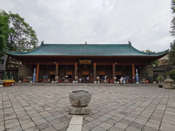 Chinese-style prayer hall building with green tiled roof and courtyard