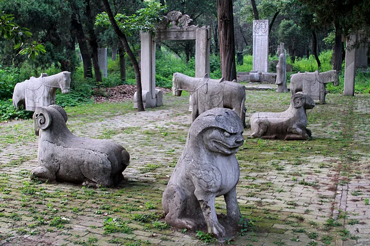 Stone animal statues (horses and mythical beasts) lining a Ming-dynasty spirit way among trees