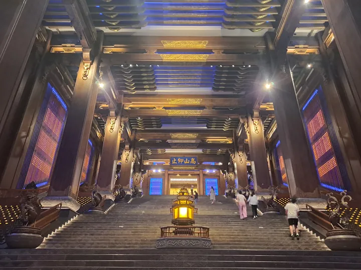Ornate wooden hall interior with a grand staircase at Nishan Shengjing, Qufu