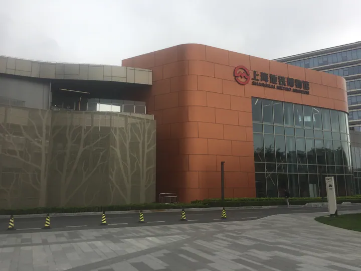 The orange-clad entrance of the Shanghai Metro Museum with its name displayed above the glass doors