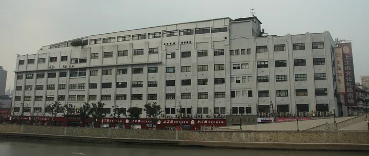 Exterior of the multi-storey Sihang Warehouse building beside a river