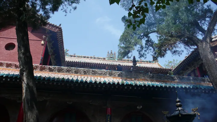 Ornate multi-tiered temple eaves against a blue sky at Xiaoxitian, Xi County