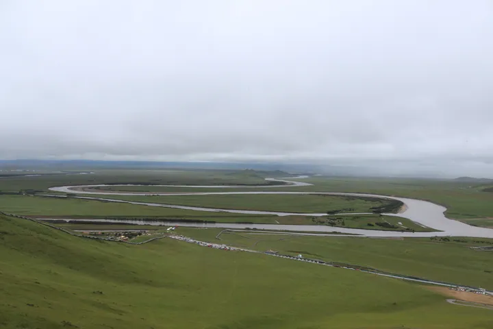 Wide grassland with the Yellow River curving in a large S-shaped bend