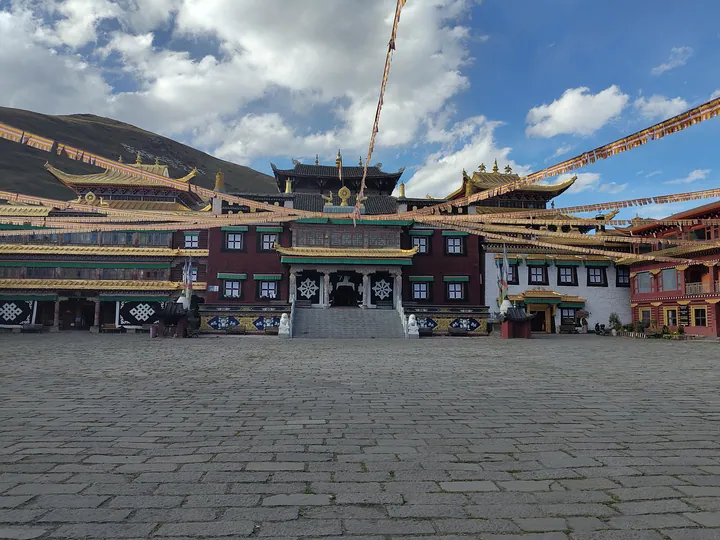 Tagong Monastery's main hall with prayer flags strung across the courtyard