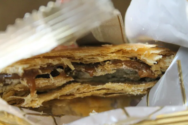 A cross-section of a flaky pastry with caramel filling.