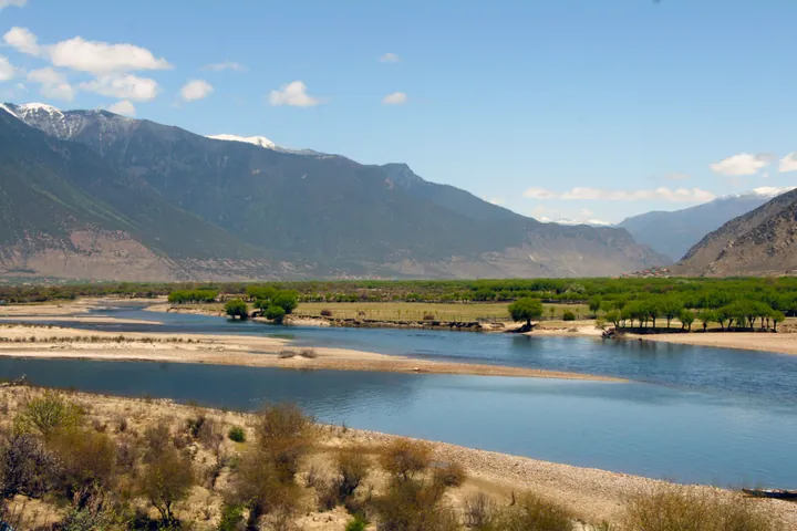 Wide river with sandbars flowing through a mountain valley in Tibet