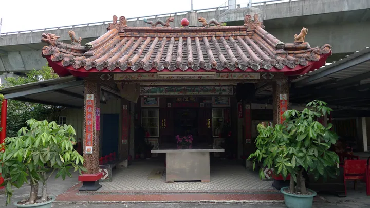 A traditional red-and-gold Chinese temple building with an ornate tiled roof