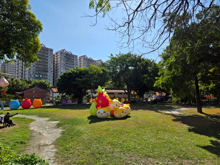 Park scene with festival decorations and the city skyline behind, Yuanlin City