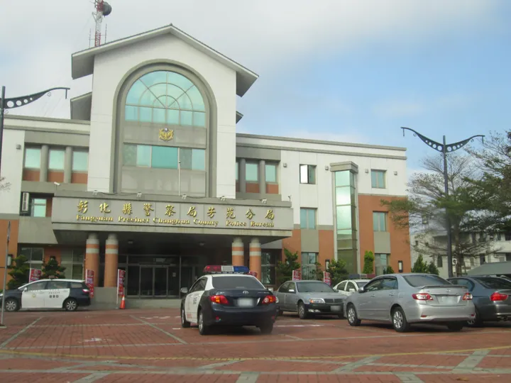 A modern police station building with parked patrol cars in front