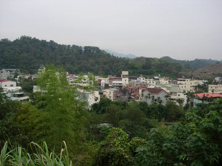 A hillside hamlet with houses among trees, seen from an overlook