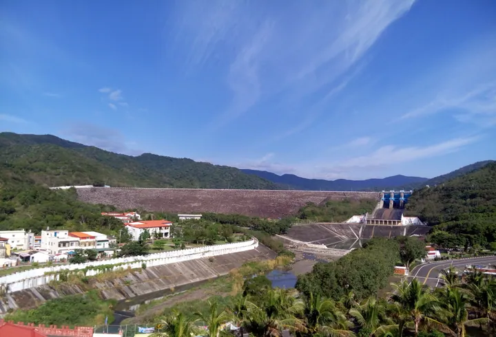 A dam and reservoir surrounded by green mountains in Mudan Township