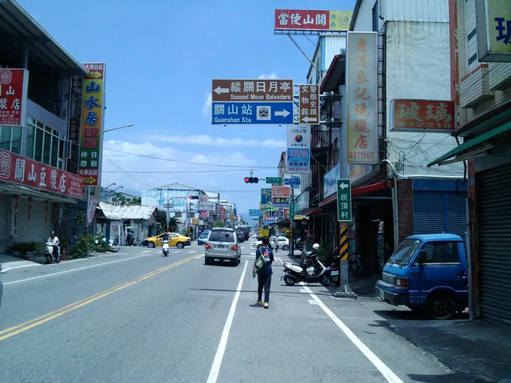 Shop-lined street with signage for Guanshan Station