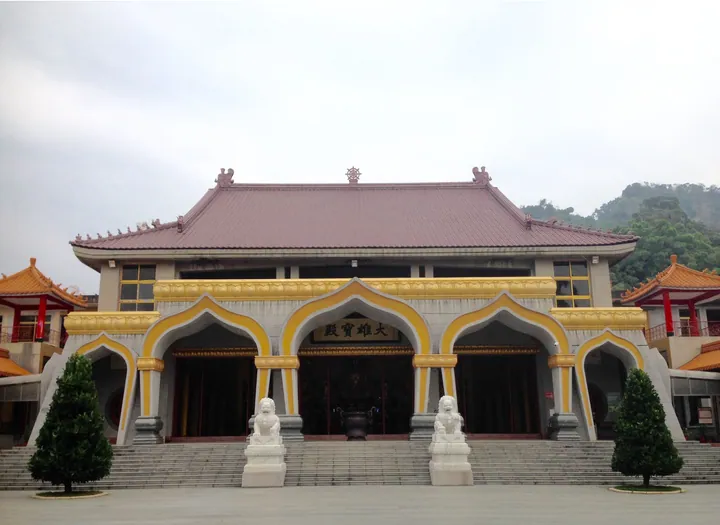 Grand golden-arched temple hall with stone lion statues in Dashe District