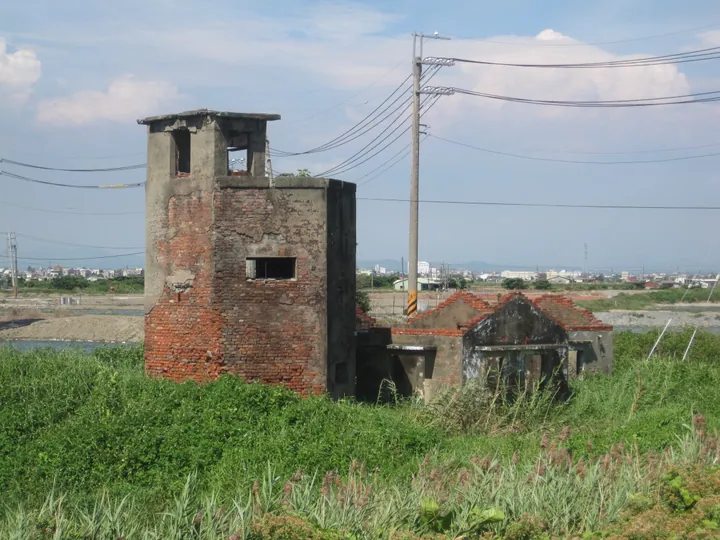 Brick watchtower ruin amid green fields, Qieding District