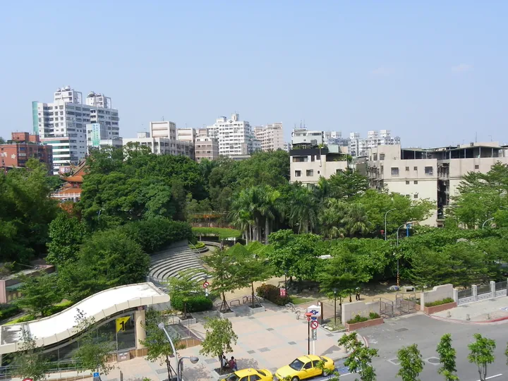 Green park with a city skyline in the background in Tucheng District