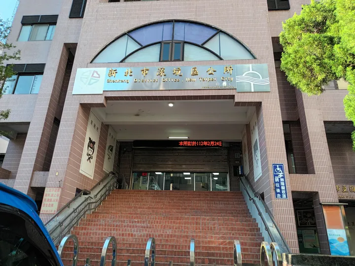 Multi-storey brick building with a large arched window and a sign reading Shenkeng District Office, New Taipei