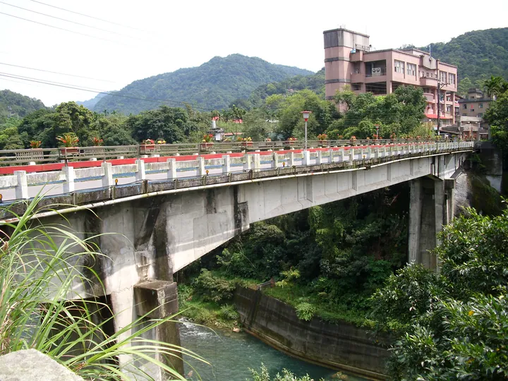 Concrete bridge with red and white railings crossing a river in Shiding District