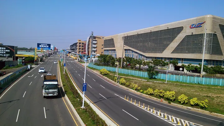 A wide road beside a modern terminal building near Taichung Airport