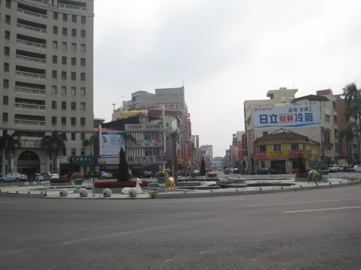 A roundabout surrounded by shops and signage in Xinying District