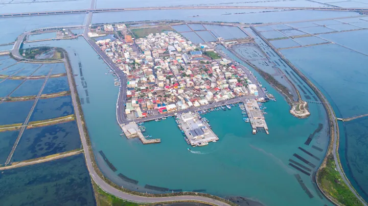 Aerial photo of a coastal fishing settlement surrounded by fish ponds and water