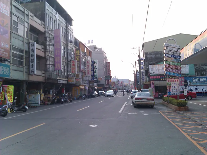A township street lined with shops and a gas station in Shanhua District
