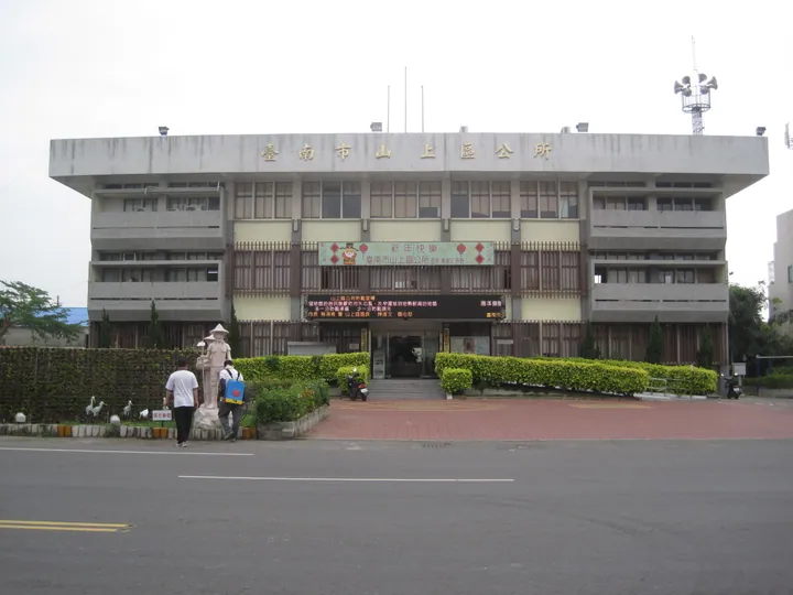 Government office building with a statue and banners in Shanshang District